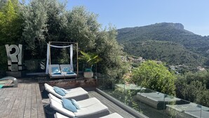 A rooftop terrace with lounge chairs and a canopy, overlooking a mountainous landscape. - Luxury studio suite in artist Villa with sea view (Eze)