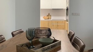 A dining area with a wooden table, chairs, a glass, and a basket labeled "Farmers Market".