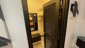 Un corridoio con una porta chiusa, una panca e una lampada.