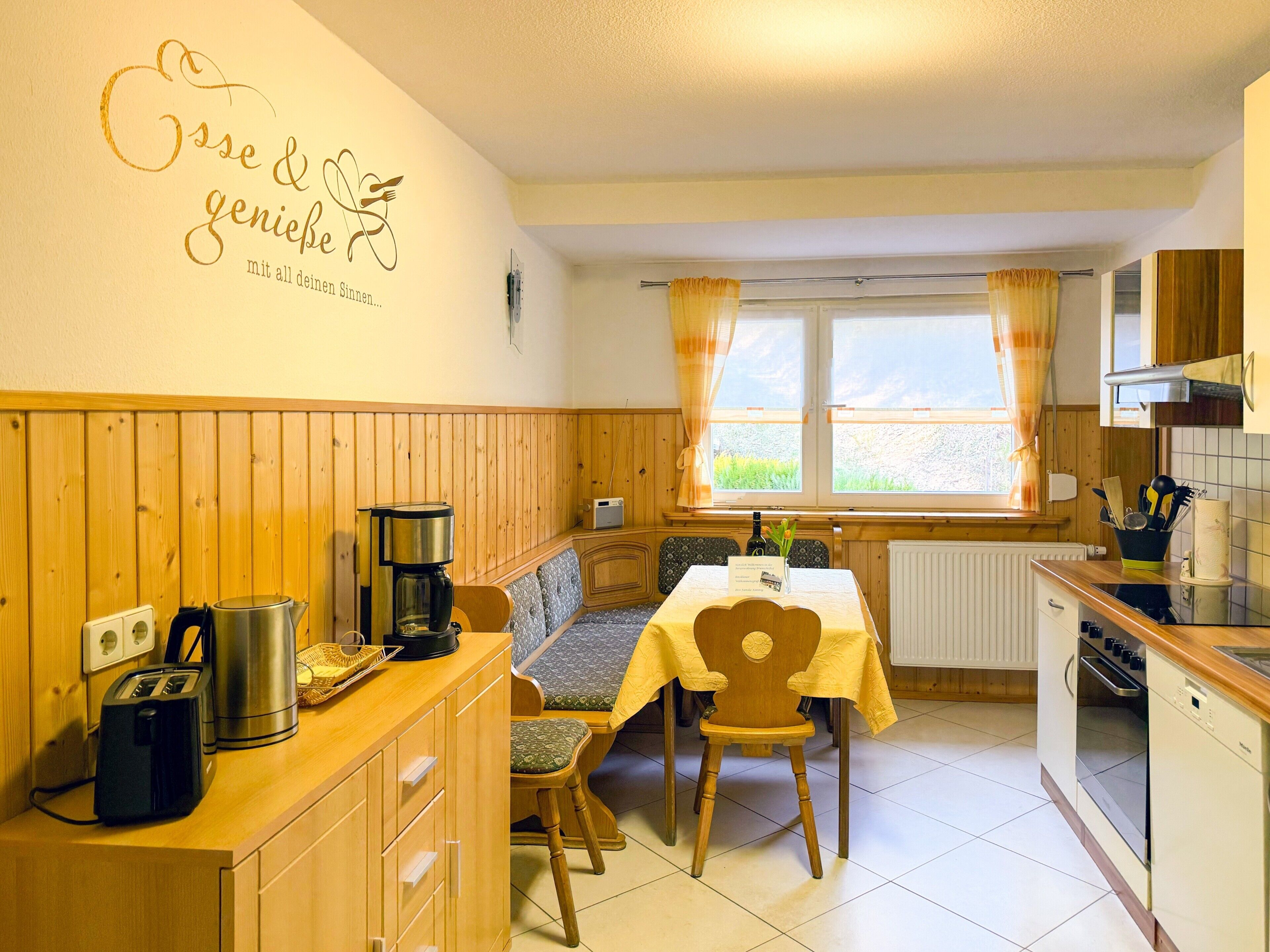 A cozy kitchen with wooden paneling, a dining table, and a bench.