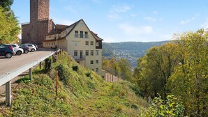 Un bâtiment doté d’une tour imposante, d’un espace de stationnement et offrant une vue sur une vallée.