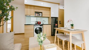 A modern kitchen with wooden cabinets, a washing machine, and a refrigerator. - The Euphoria Hanoi (Hanoi)