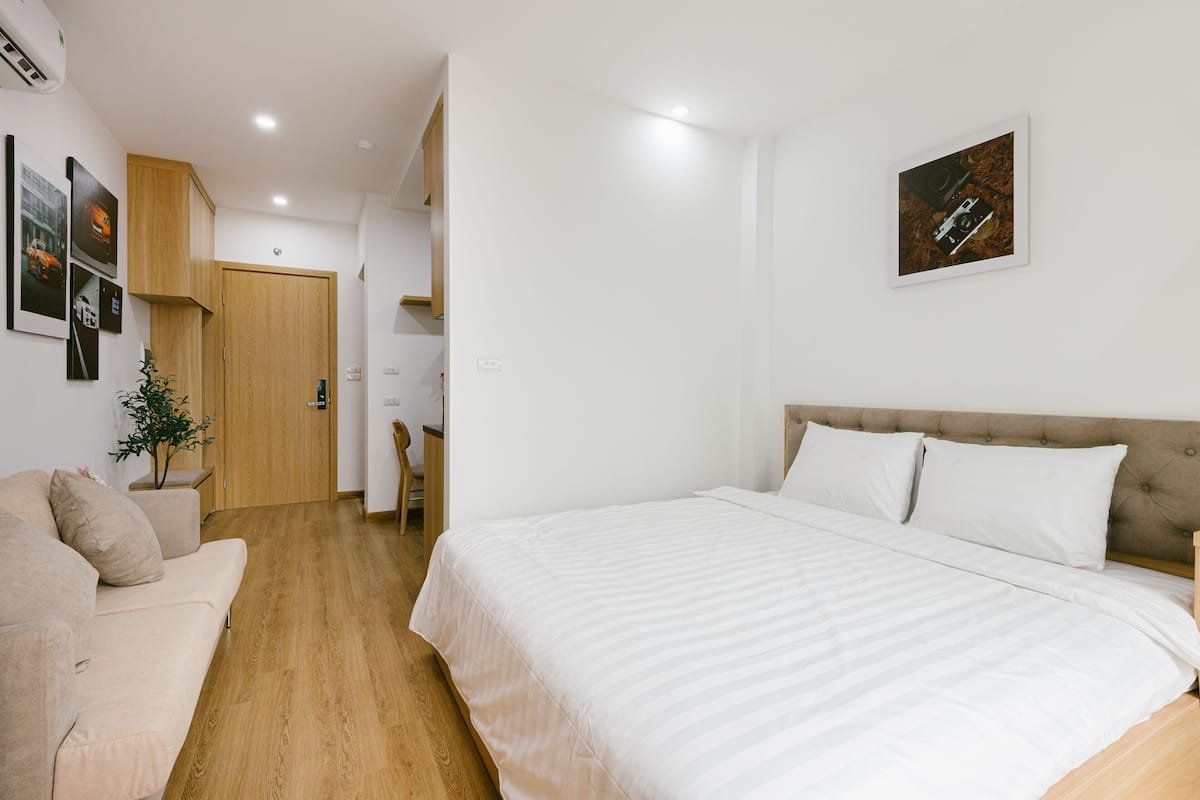 Ein Schlafzimmer mit einem Bett, einem Schlafsofa und Holzboden.