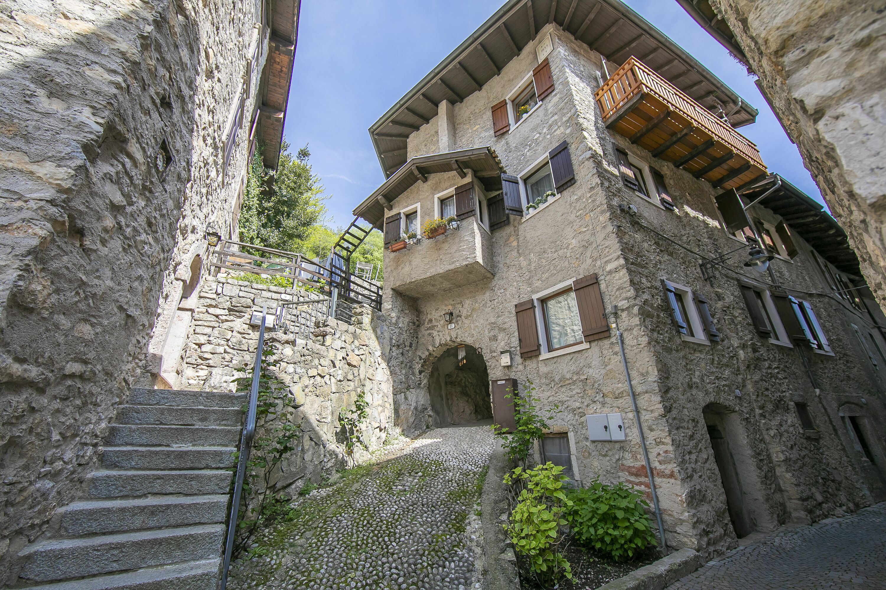 A narrow stone staircase leading to a building with multiple balconies and windows.
