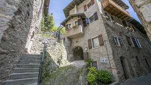 Un escalier étroit en pierre mène à un immeuble doté de nombreux balcons et fenêtres.