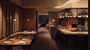 A modern dining area with wooden tables and chairs, a central bar, and a kitchen with a wood-fired oven. - TRUNK HOTEL YOYOGI PARK (Tokyo)