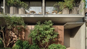 A modern building with a balcony, a tree, and a sign that reads "TRINK HOTEL". - TRUNK HOTEL YOYOGI PARK (Tokyo)