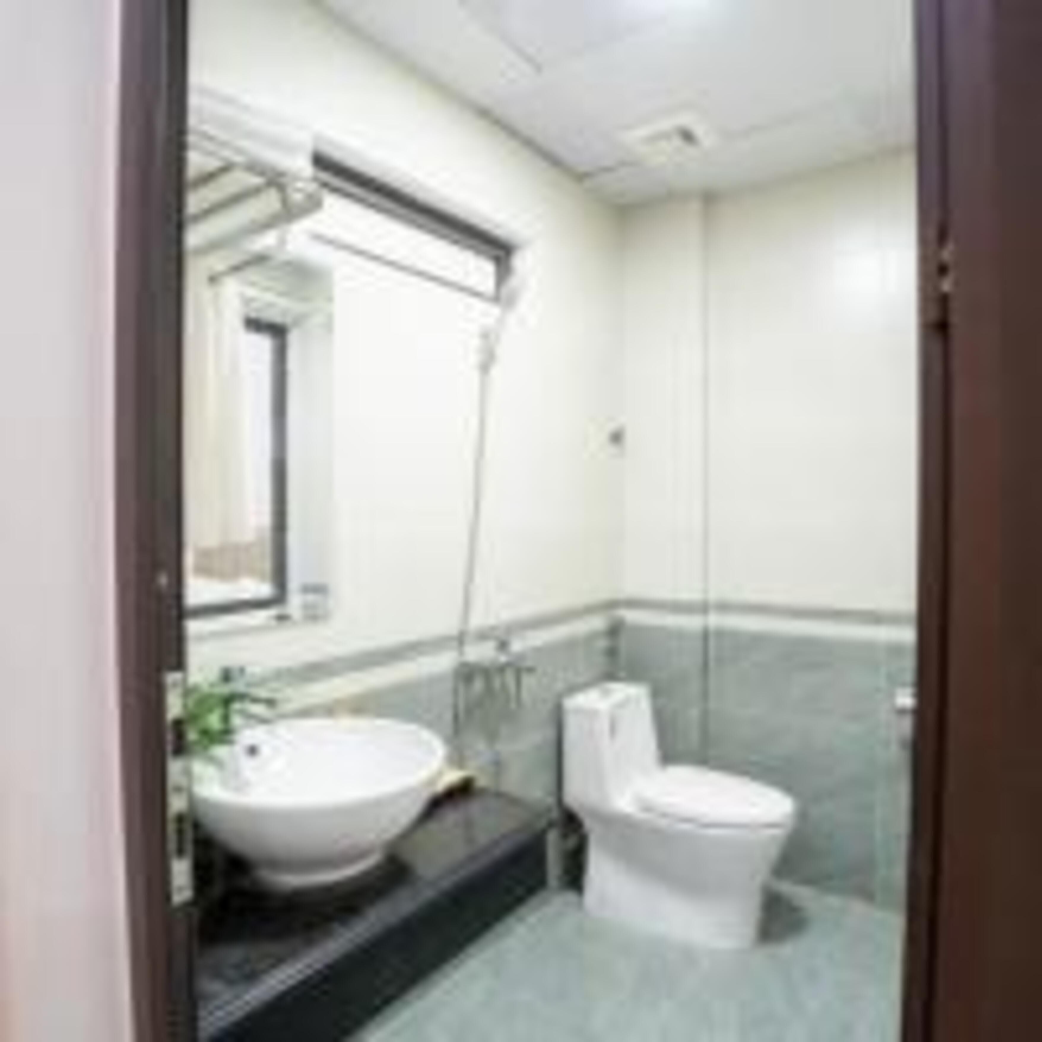 A bathroom with a white sink, mirror, and toilet.