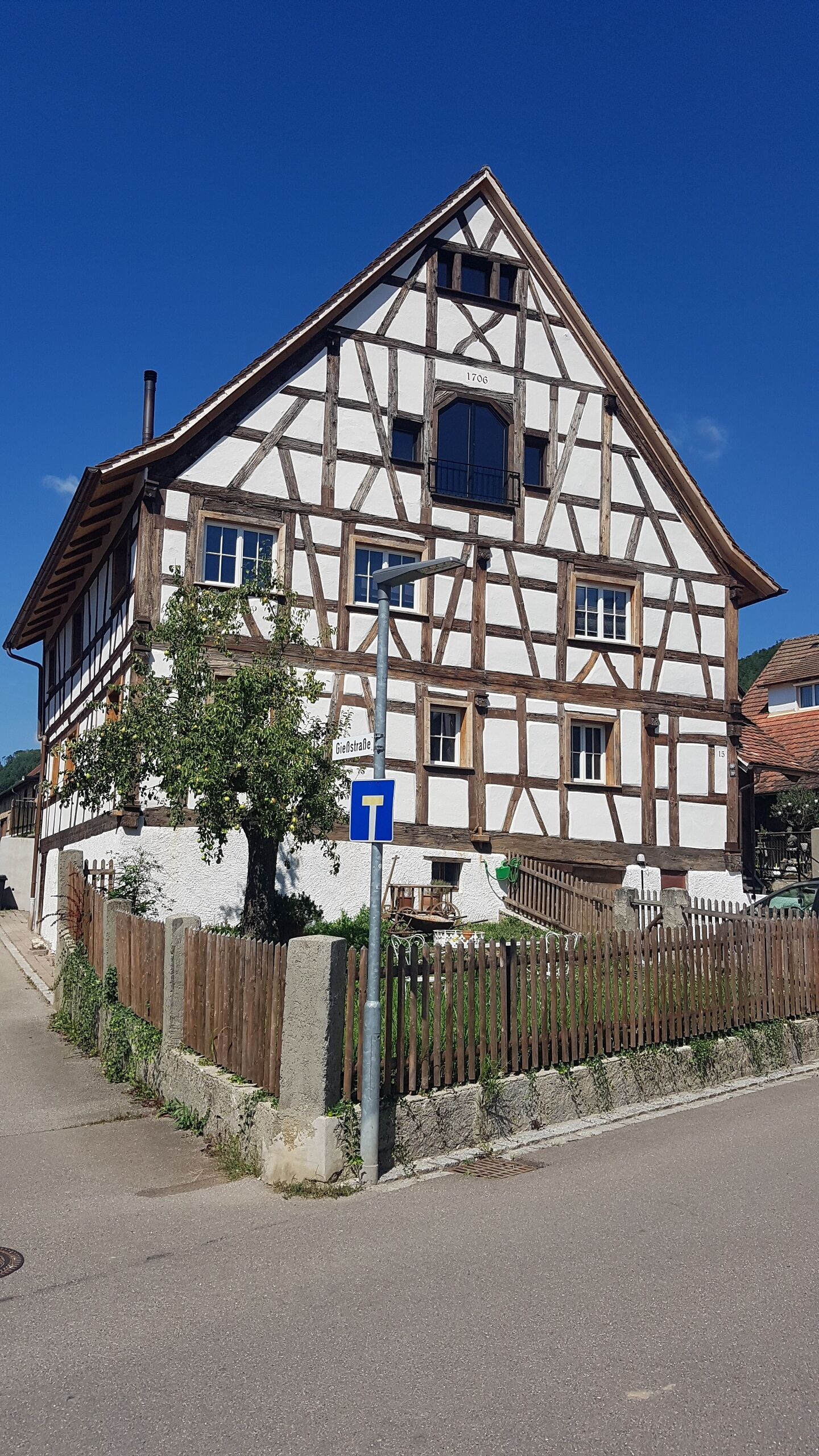 A traditional half-timbered house with a visible street sign indicating a T-junction.