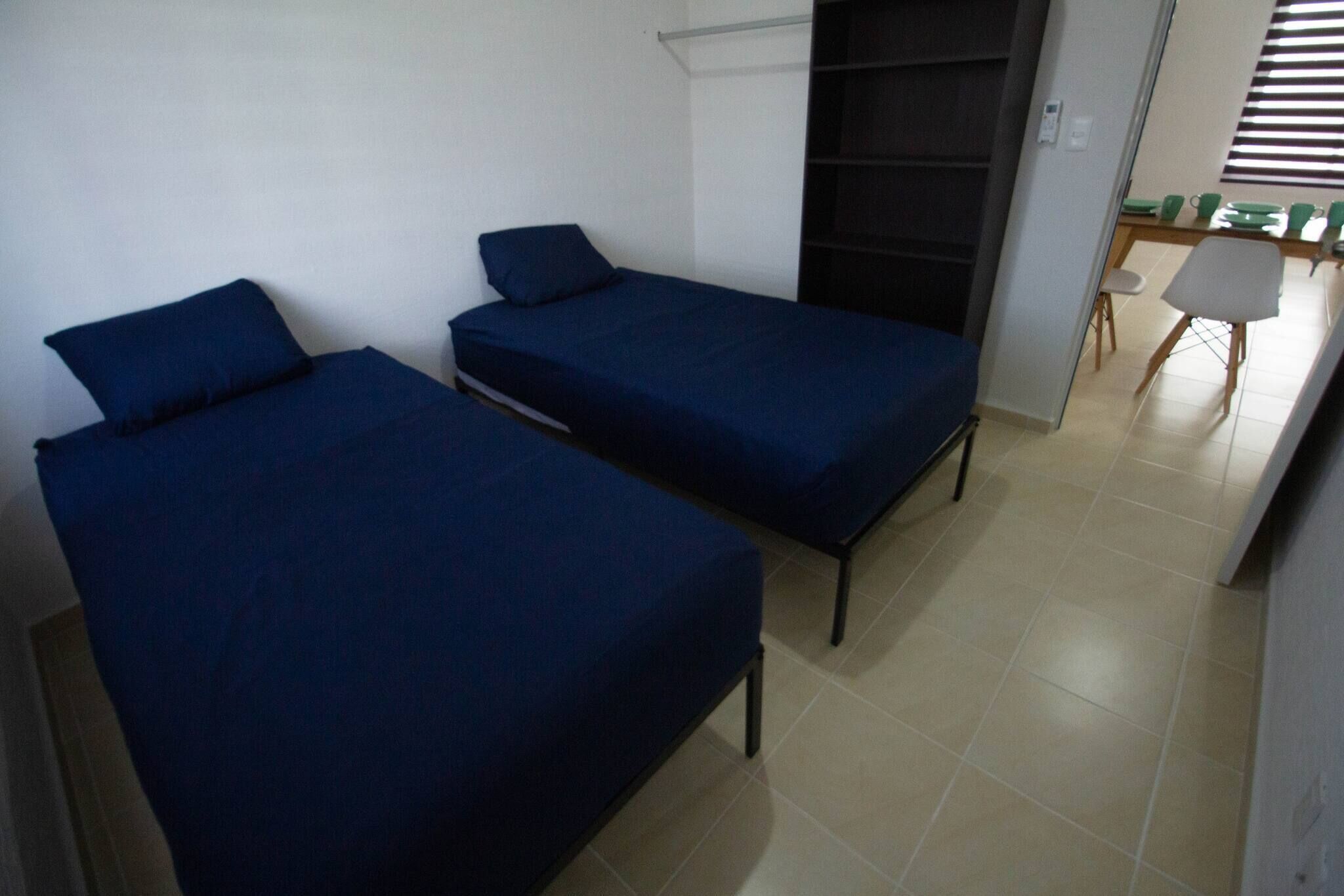 Une chambre avec deux lits, un bureau et une chaise.