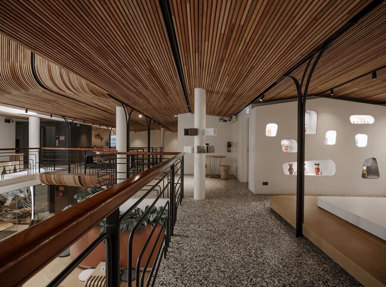A modern interior with a wooden ceiling, a central white pillar, and a seating area with tables and chairs.