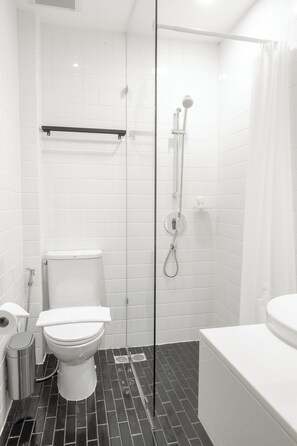 A bathroom with a toilet, a shower, and a bathtub.