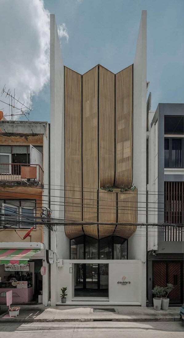 A modern building with a unique vertical design, featuring a central atrium with a slatted facade.