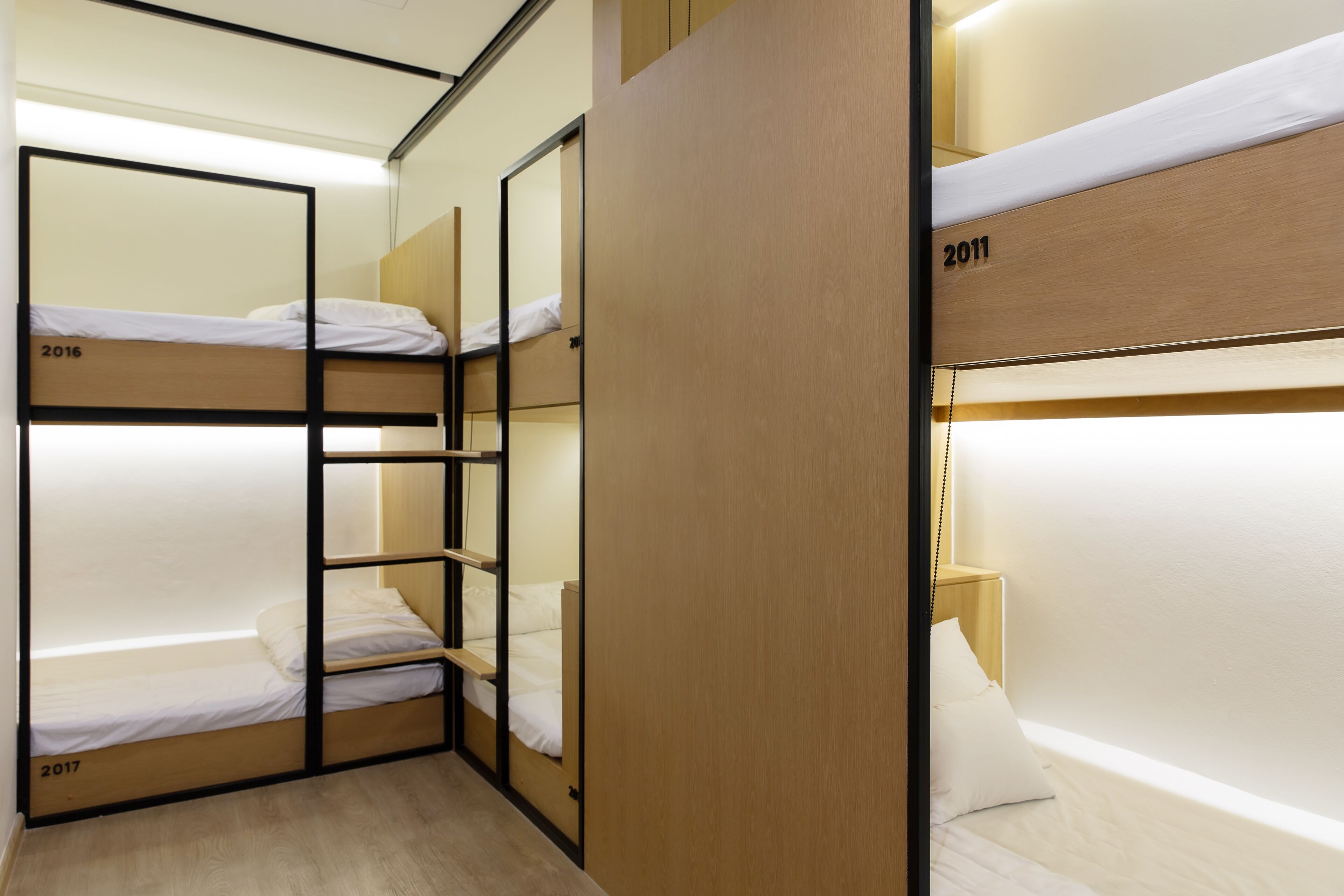 A dormitory-style room with bunk beds, each labeled with a year.