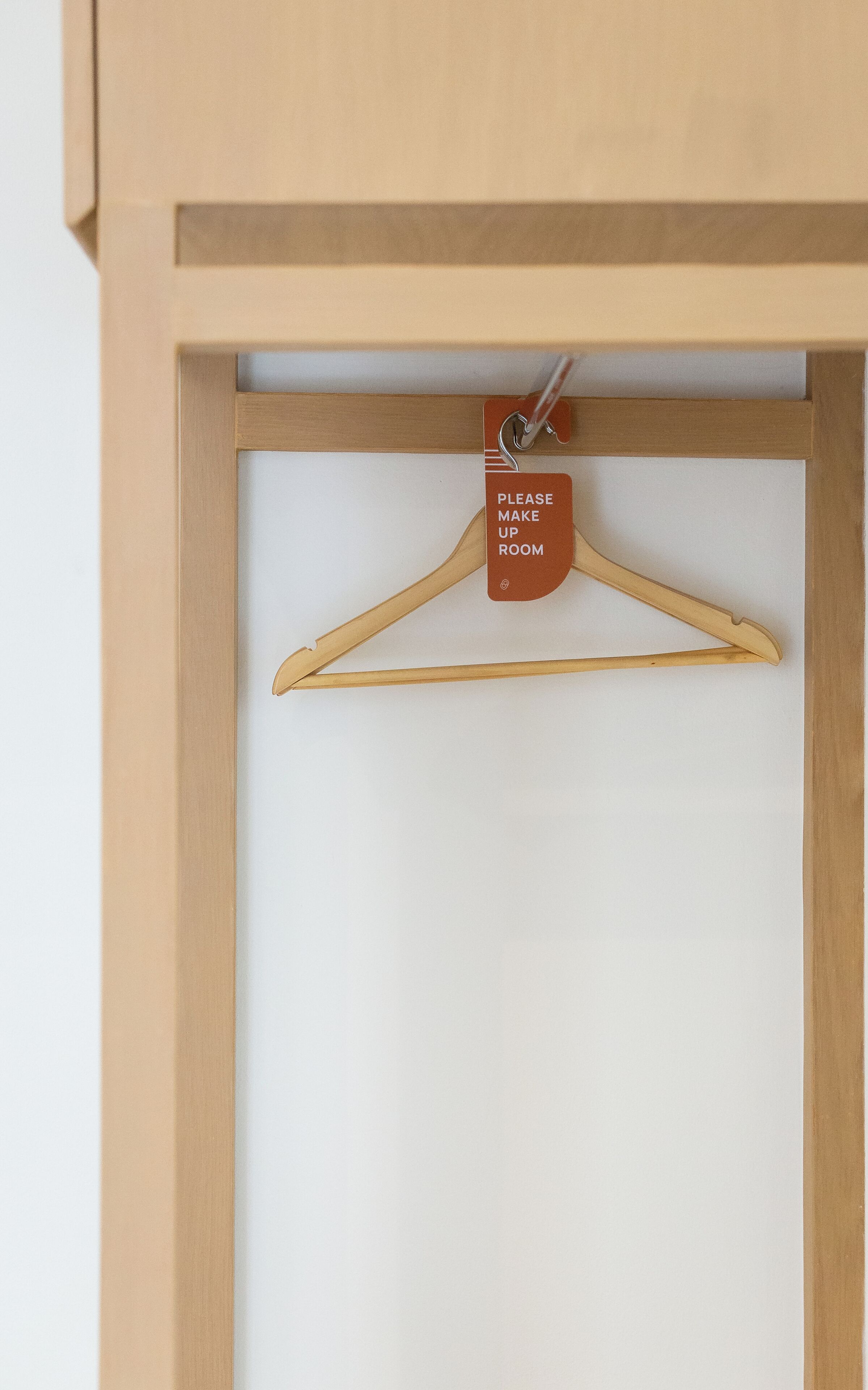 A wooden frame with a white background and a hanger labeled "PLEASE MAKE UP ROOM".