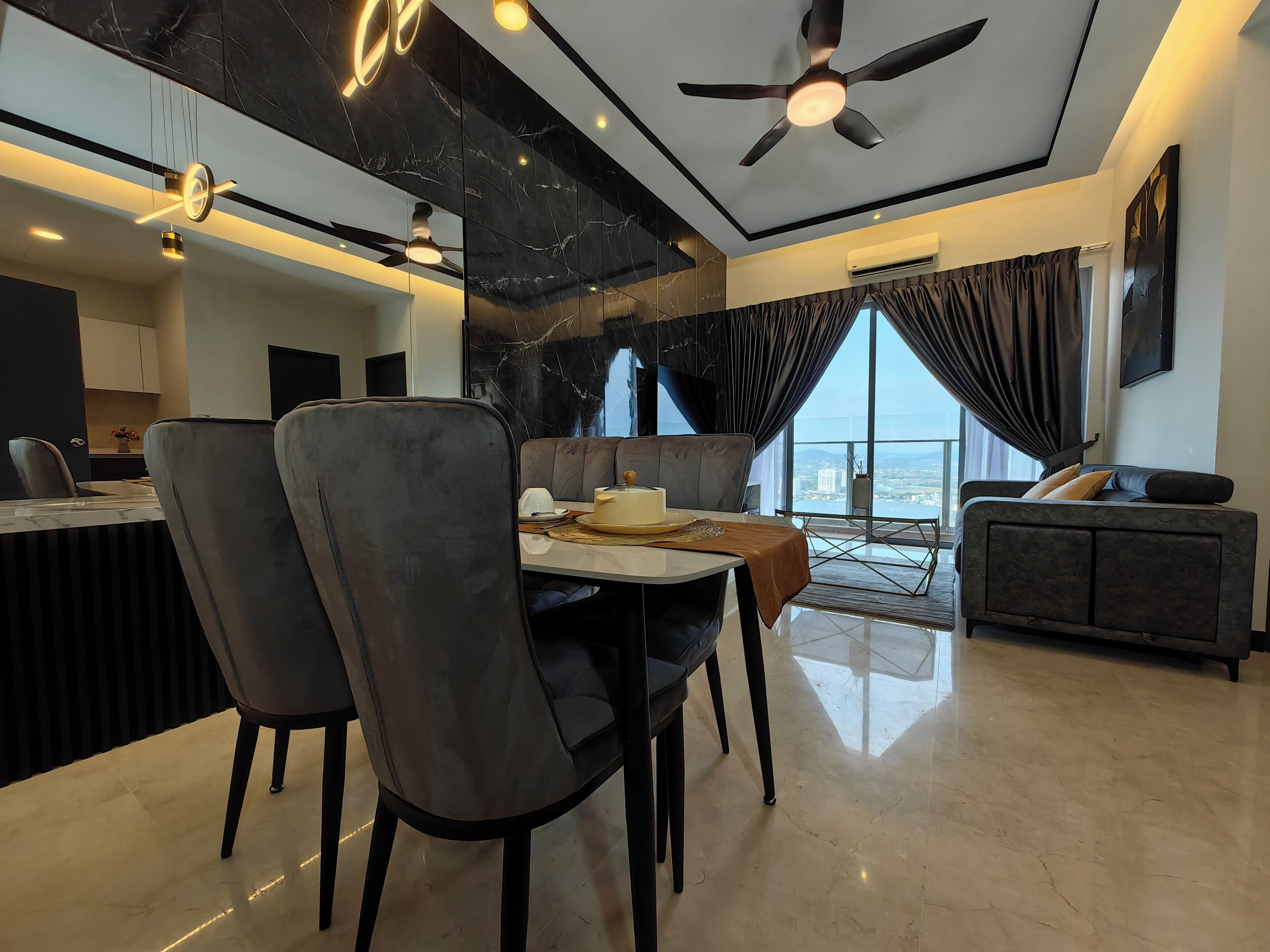 A modern living room with a dining area, a sofa, and a view of the city.