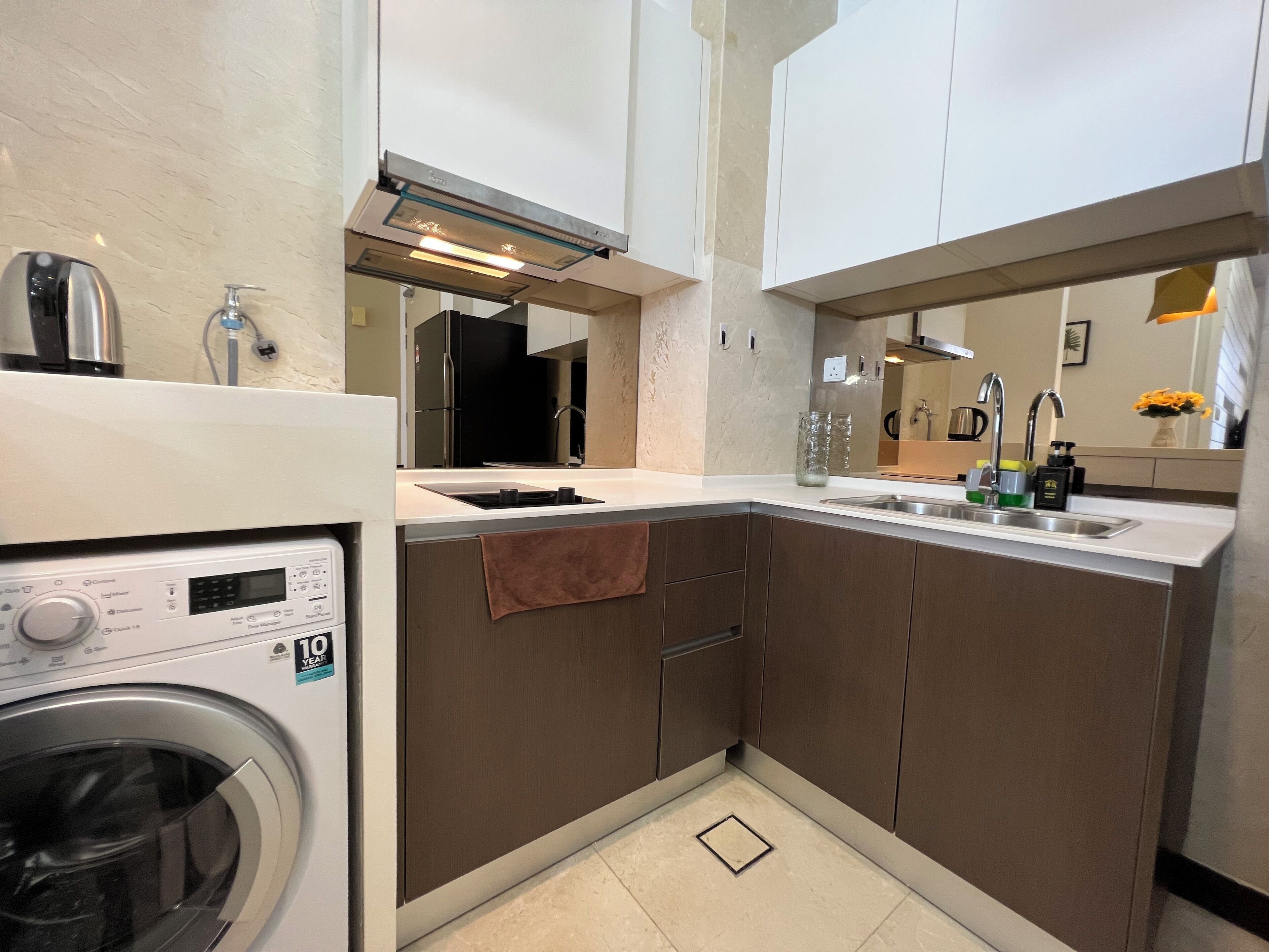 A compact kitchen with a built-in washing machine, a sink, and a stove.