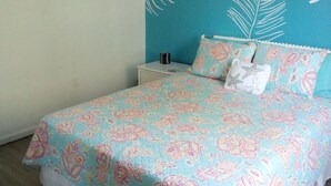 A bedroom with a bed, a nightstand, a wall with artwork, and a ceiling fan. - Townhouse style condo in beautiful resort across the street from Gulf of Mexico! (Panama City)