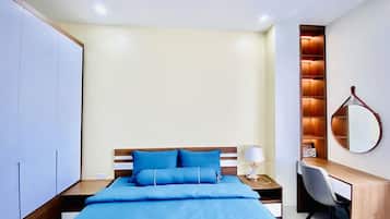 Un dormitorio con cama, mesita de noche, lámpara, escritorio, silla y armario.