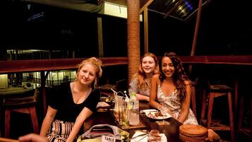 Three people seated at a table with a table number sign, a menu, and a drink.