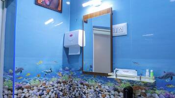 Une salle de bain avec un mur bleu, un tableau encadré, un lavabo, un miroir et un aquarium.