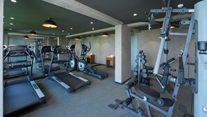 A gym with treadmills, elliptical machines, and weightlifting equipment. - Noah Sky Suites (Aluva)