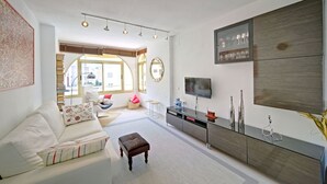 A modern living room with a sofa, a coffee table, a TV, and a cabinet.