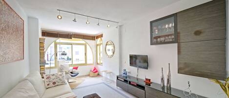 A modern living room with a sofa, a coffee table, a TV, and a cabinet.