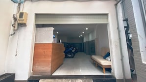 Entrada de garaje con mostrador de recepción de madera, una motocicleta y un sofá.