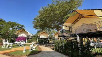 Caravans surrounded by manicured lawns and decorative statues, offering a tranquil retreat.