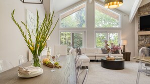 A spacious living area with a large dining table, a sofa, and a fireplace.