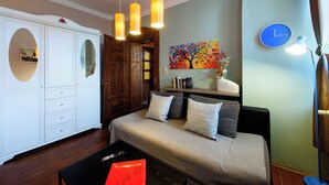A bedroom with a bed, bedside tables, a wardrobe, and a painting on the wall.