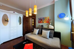 A bedroom with a bed, bedside tables, a wardrobe, and a painting on the wall.