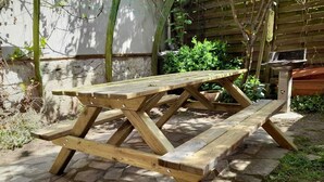 Un tavolo da picnic in legno con un patio in pietra.