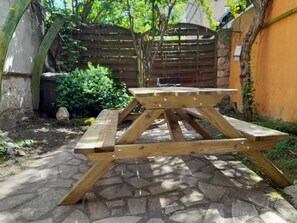 A wooden picnic table with a central support and four benches.
