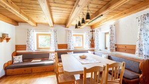 A cozy dining area with wooden furniture, a bench, and a table with a floral placemat.