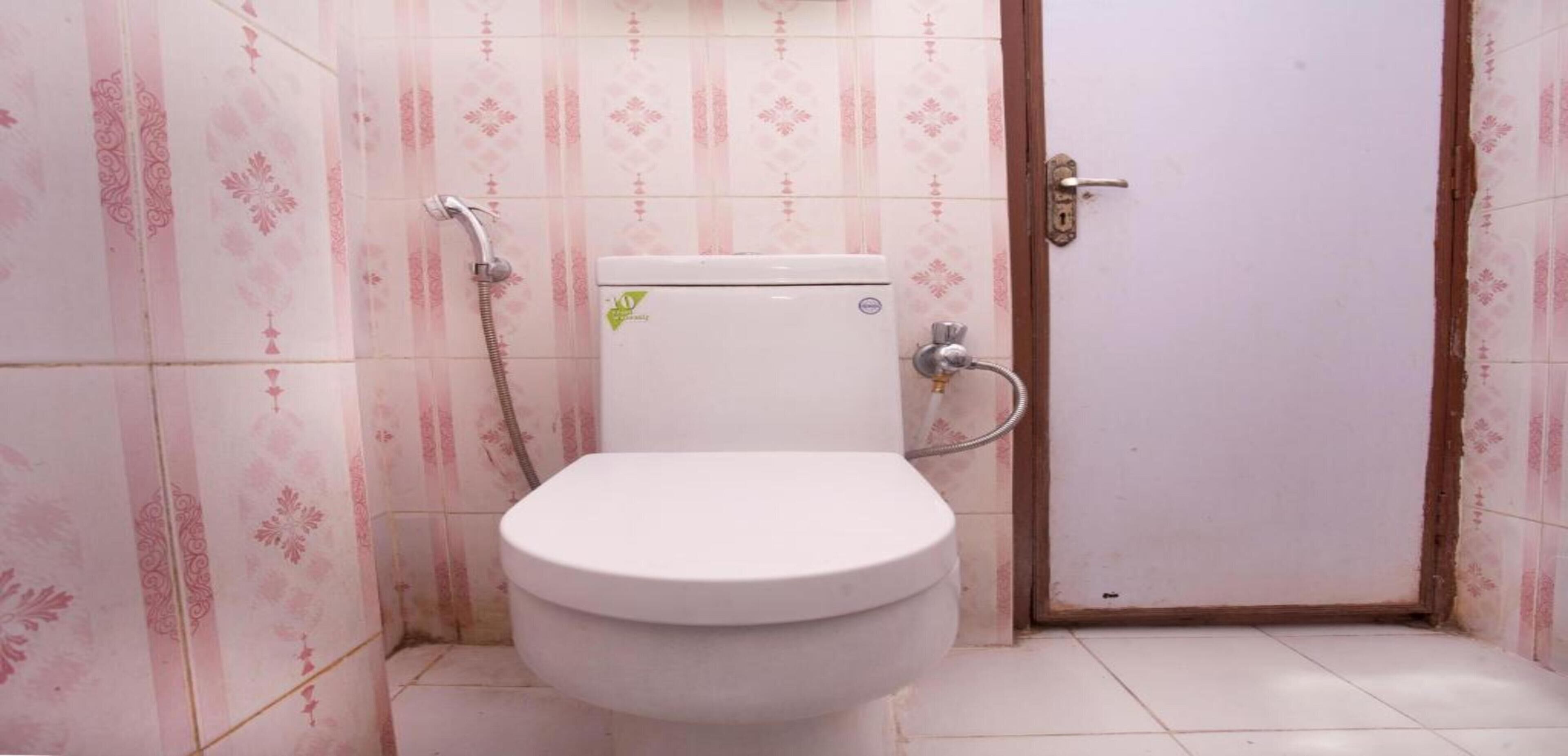 A bathroom with a toilet, a shower, and a door.