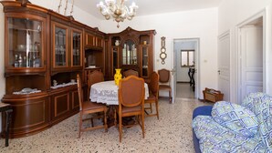 Un comedor con un aparador de madera, una araña y una mesa de comedor con sillas.