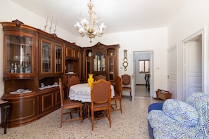 Un coin repas comprenant un buffet en bois, un lustre et une table à manger avec des chaises.