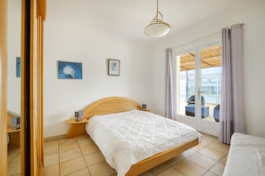 Habitación de hotel con cama, mesita de noche, cortinas y vistas al exterior.