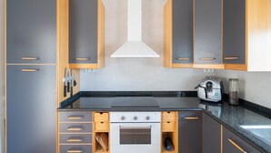 A modern kitchen with wooden cabinets, a built-in oven, and a coffee machine. - Holiday Home 'Casa Blanca Family Villa' with Private Pool, Wi-Fi & Air Conditioning (alfaz del pi)