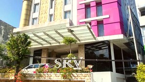 A hotel with a modern design, featuring a prominent 'SKY' sign, a covered entrance, and a car parked in front. - Surabaya River View Hotel (Surabaya)