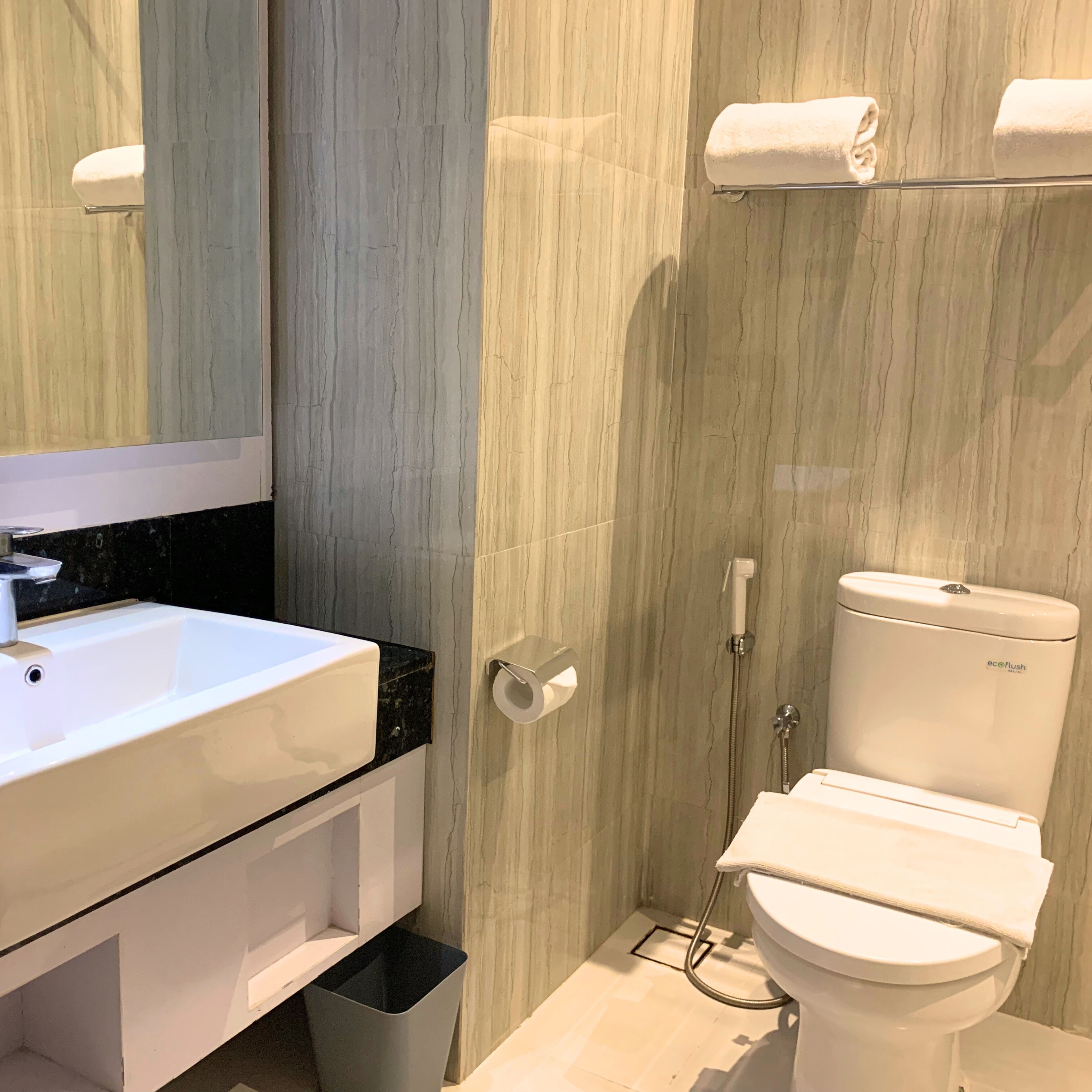 A modern bathroom with a white sink, a toilet, and a shower.
