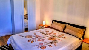 A bedroom with a bed, a wardrobe, a bedside table with a lamp, and a nightstand. - Apartment in Ancona near Passetto Beach (Ancona)