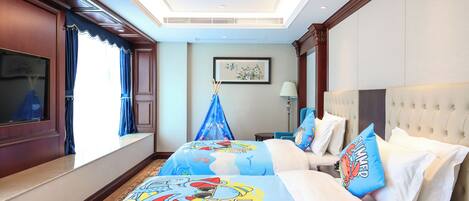 A hotel room with two beds, a large window, a flat-screen TV, and a ceiling fan.