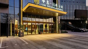 A modern building with a large glass facade and a sign for CICC Executive Apartments. - Shenzhen Guangming CIMC Executive Hotel (Shenzhen)