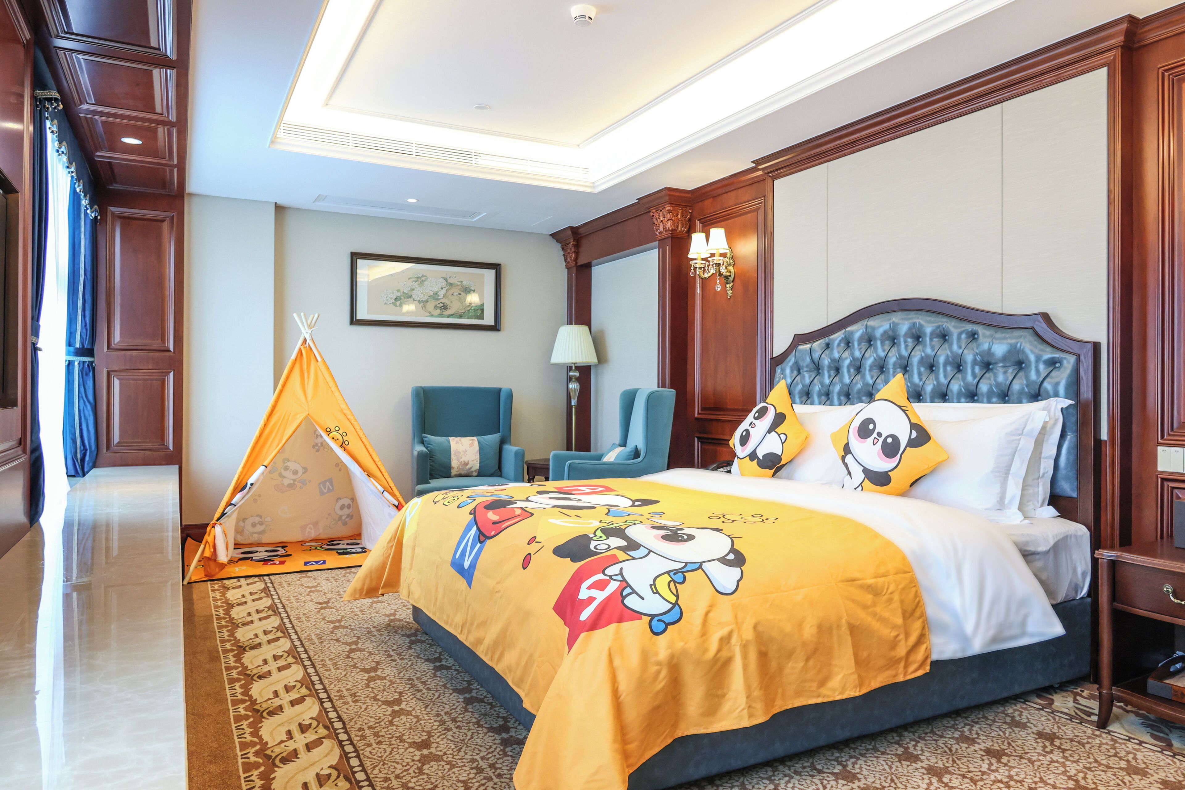 Une chambre d’hôtel avec un grand lit, une chaise bleue, une petite tente et une lampe.