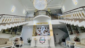 A reception area with a chandelier, a staircase, and a sign reading 'RECEPTION'. - Shark Yulduzi (Bukhara)