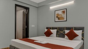 Una habitación de hotel moderna con una cama grande, un ventilador de techo y una obra de arte enmarcada en la pared.
