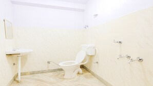 Baño pequeño y limpio con inodoro, lavamanos y ducha.